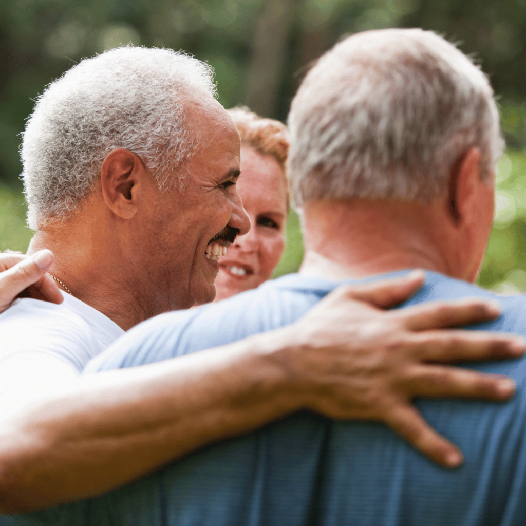 Group of older friends embracing and laughing together